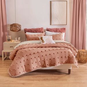 It includes decorative covers with pompoms and 1 printed cushion.